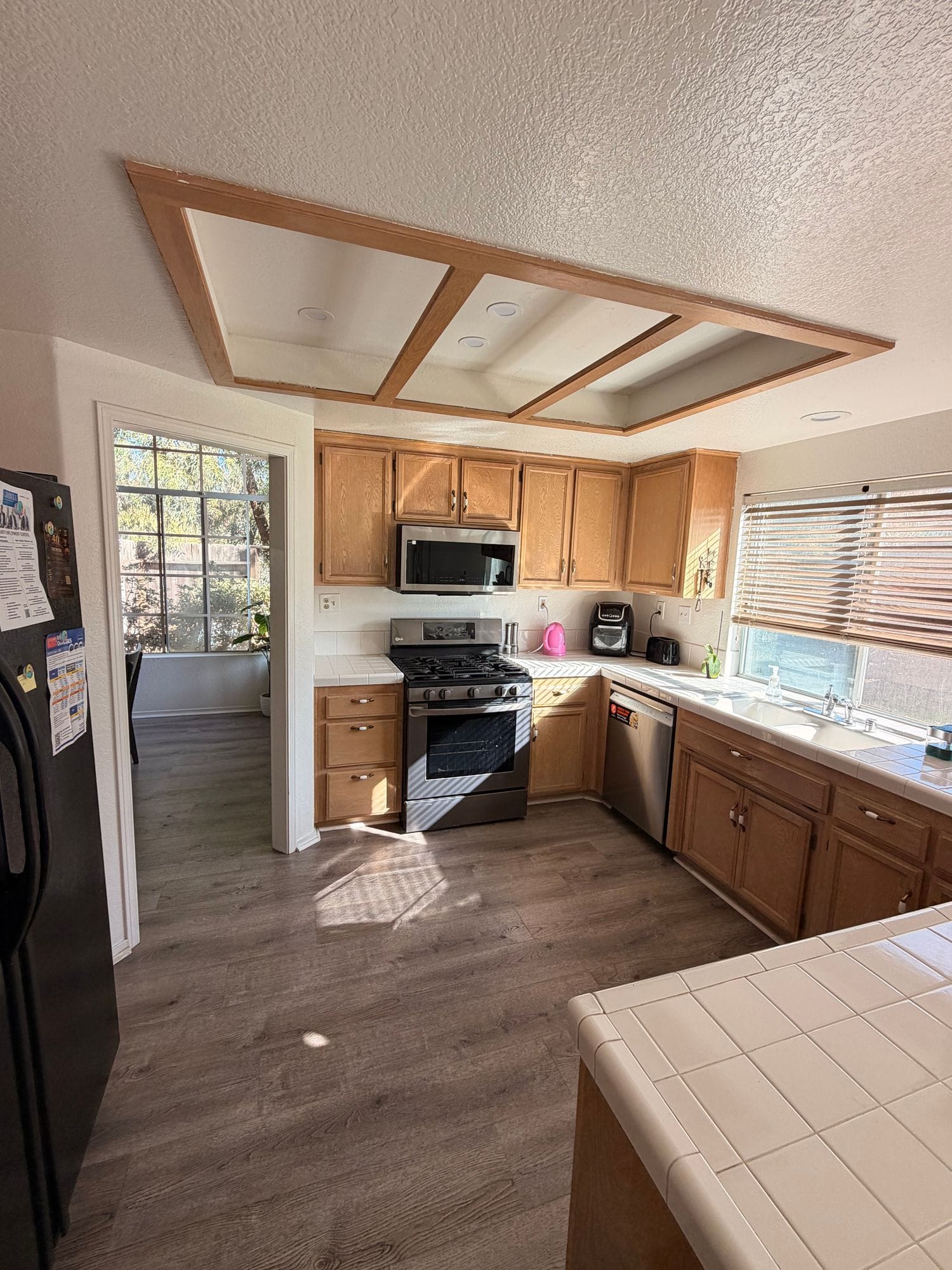 Parkhouse kitchen with wood cabinets, a gas range, a stainless dishwasher and a window over the sink