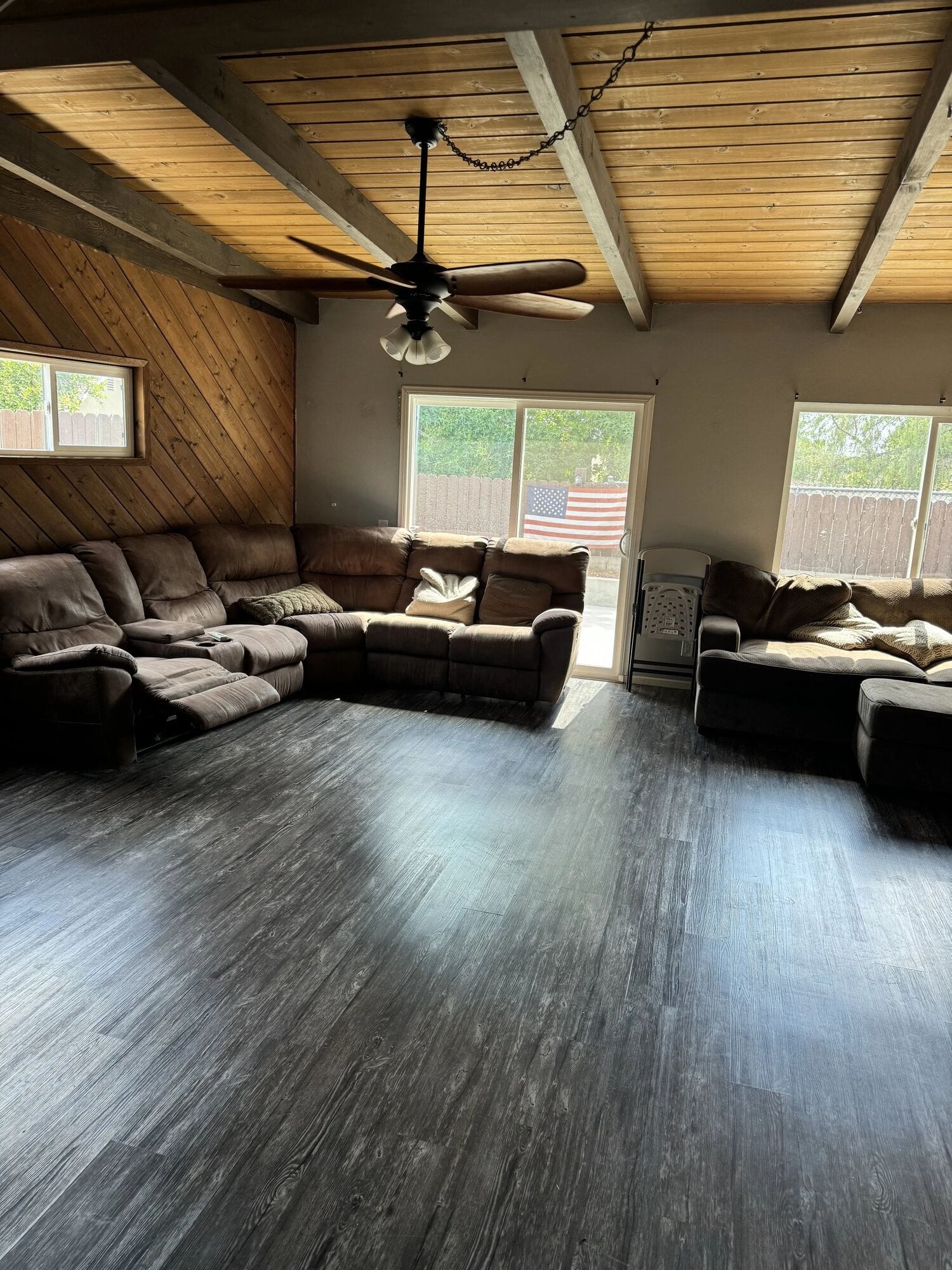 Poolhouse family room with reclining sofas under a wood-plank ceiling
