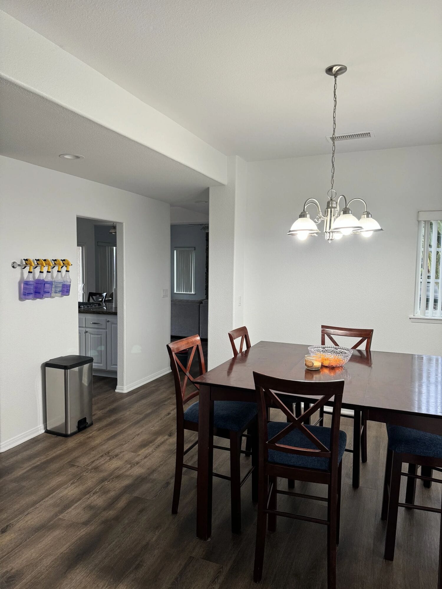 Skyhouse dining area with a wood table, four chairs and a chandelier